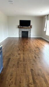 Refinished living room floor after a sand and finish Southington Ct project by Mobile, showing smooth and glossy hardwood.