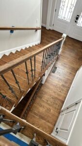 Refinished staircase and entryway after a sand and finish Southington Ct project by Mobile, showing detailed woodwork and smooth finish.