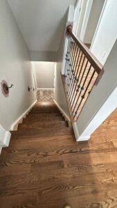 Upper staircase view after a sand and finish Southington Ct project by Mobile, highlighting the smooth hardwood transition.