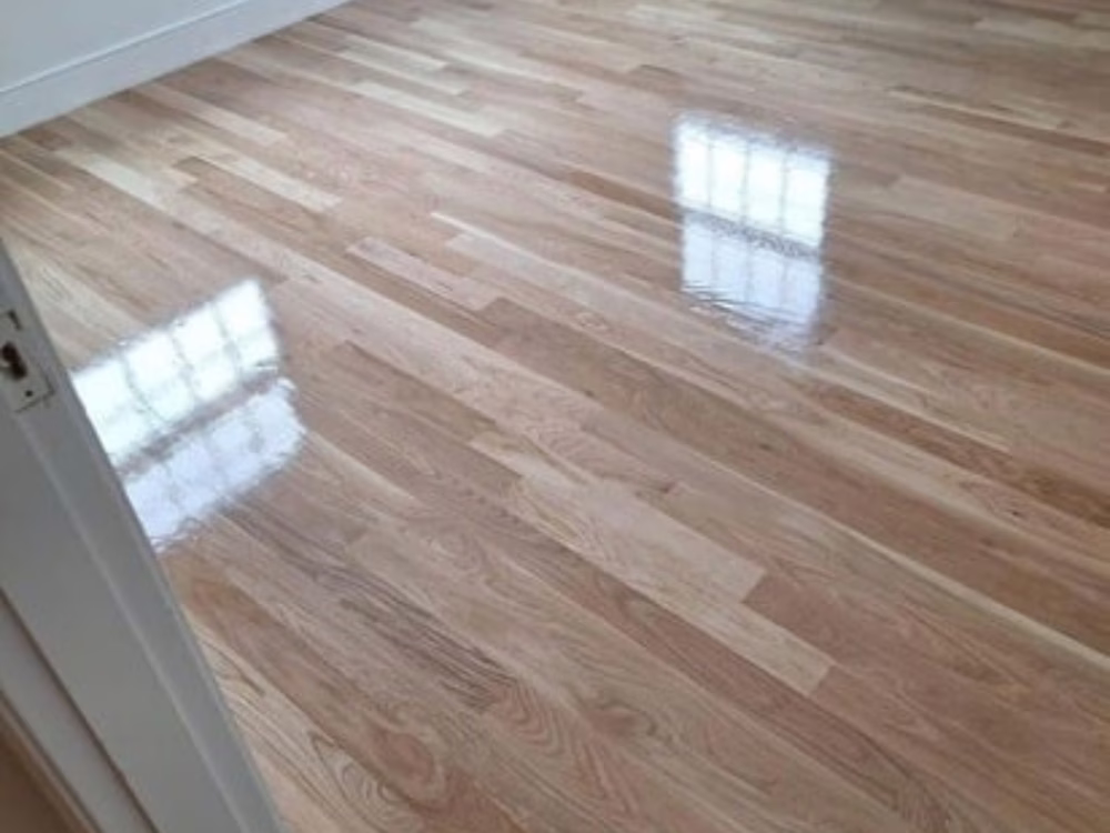 Hardwood floor refinishing with smooth glossy finish.