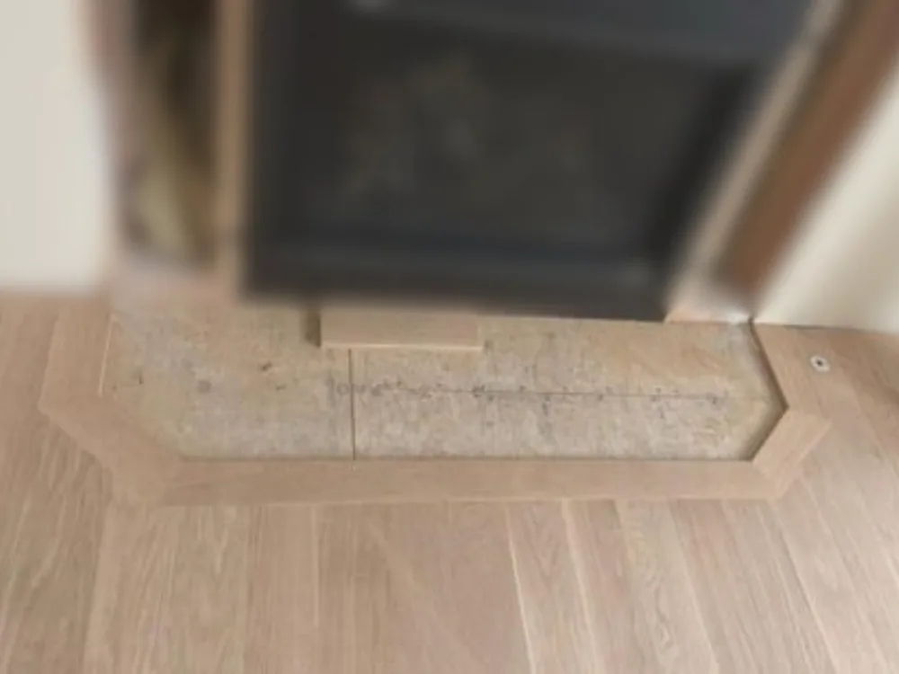 Close-up of flooring installation around a fireplace during the project in Farmington CT.