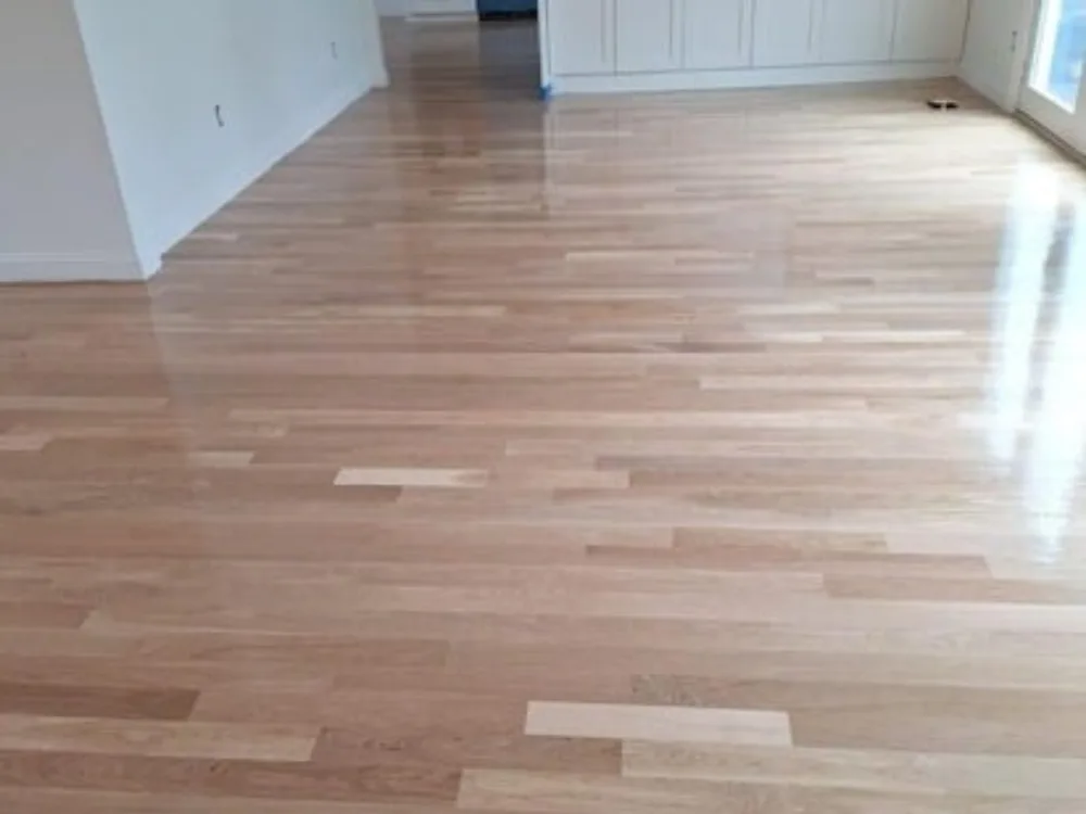 Hardwood floor sanding and refinishing in a living area connected to the kitchen.
