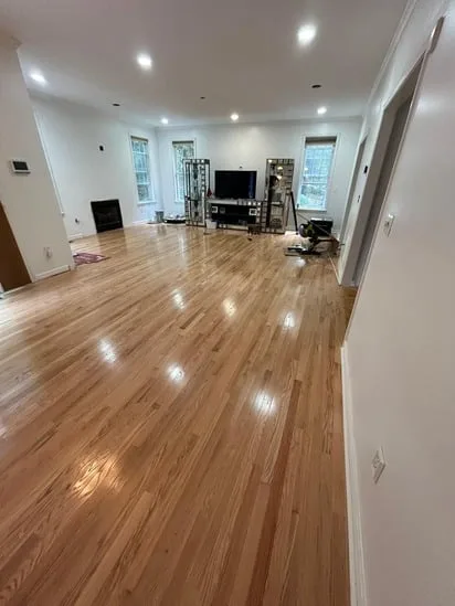 Completed hardwood replacement Granby CT showcasing the seamless transition between the living and dining areas.